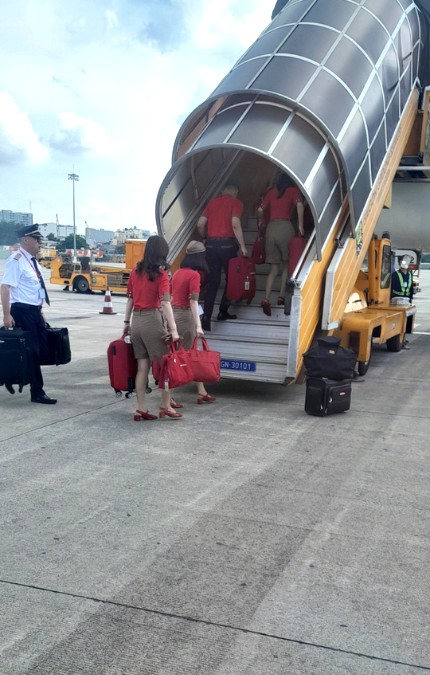 airplane staff and pilot climbing stairs to the airplane
